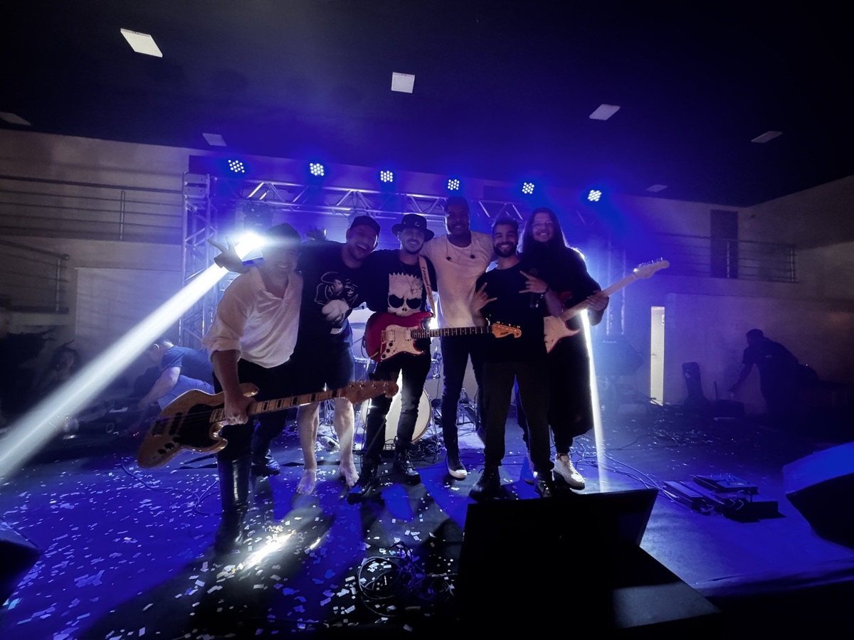 Banda e público sob luzes de palco