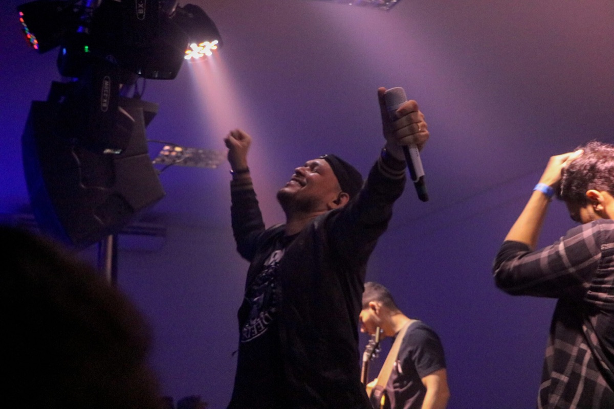 Público com braços erguidos diante do palco durante um show da Groove/SA